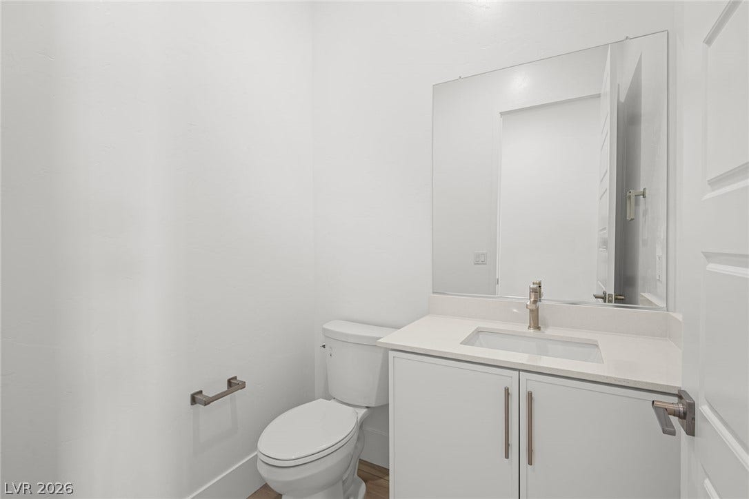 12428 Breezy Bluff Avenue, Las Vegas, NV 89138 Crisp white walls and clean lines define this modern powder room with a sleek vanity.