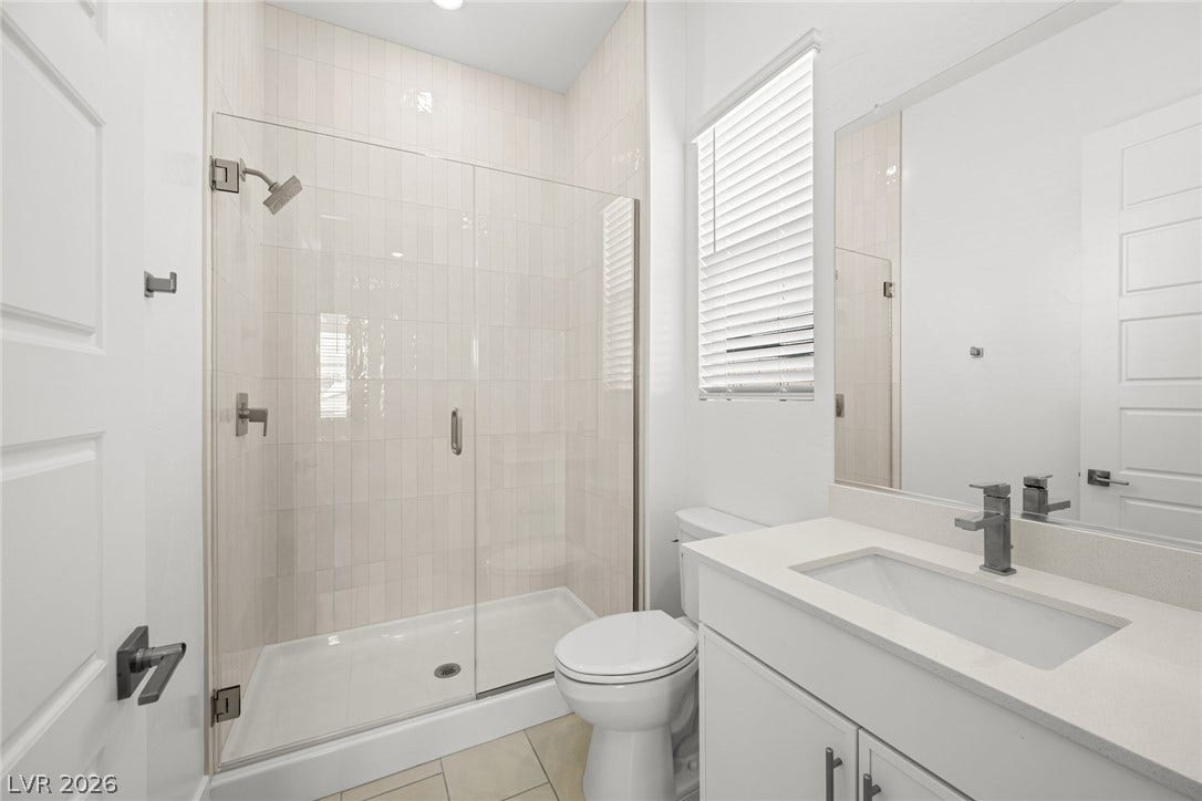 12428 Breezy Bluff Avenue, Las Vegas, NV 89138 Tiled walk-in shower with a glass enclosure sits adjacent to a modern vanity.