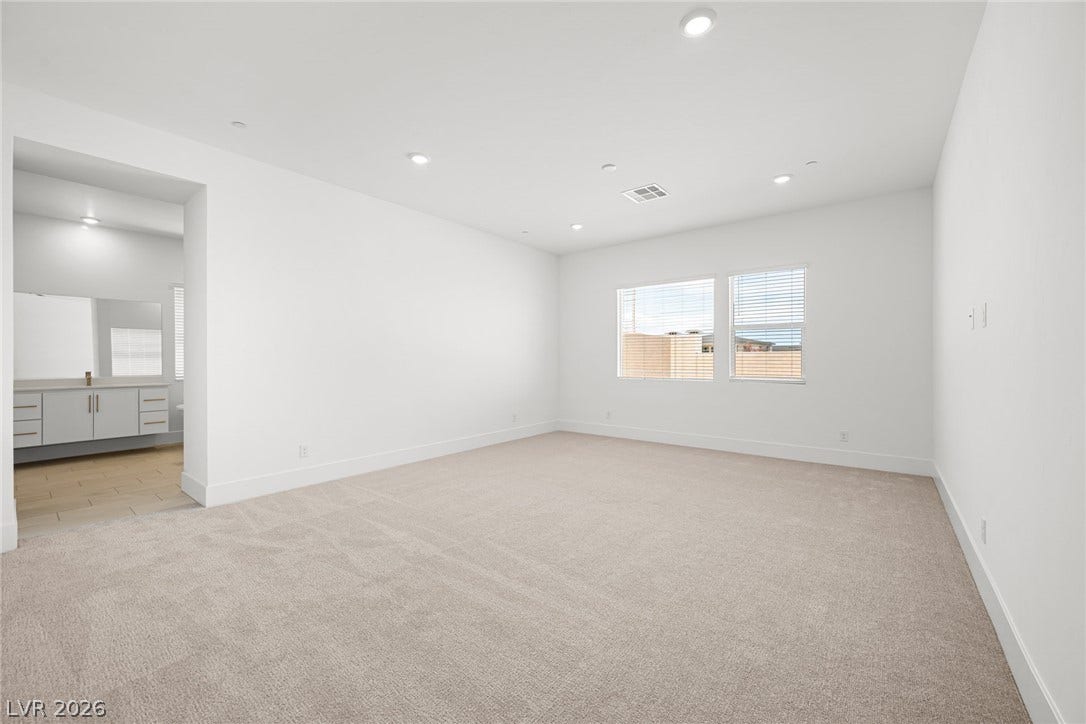 12428 Breezy Bluff Avenue, Las Vegas, NV 89138 Recessed lighting illuminates this clean suite offering plush carpeting and an attached bathroom.