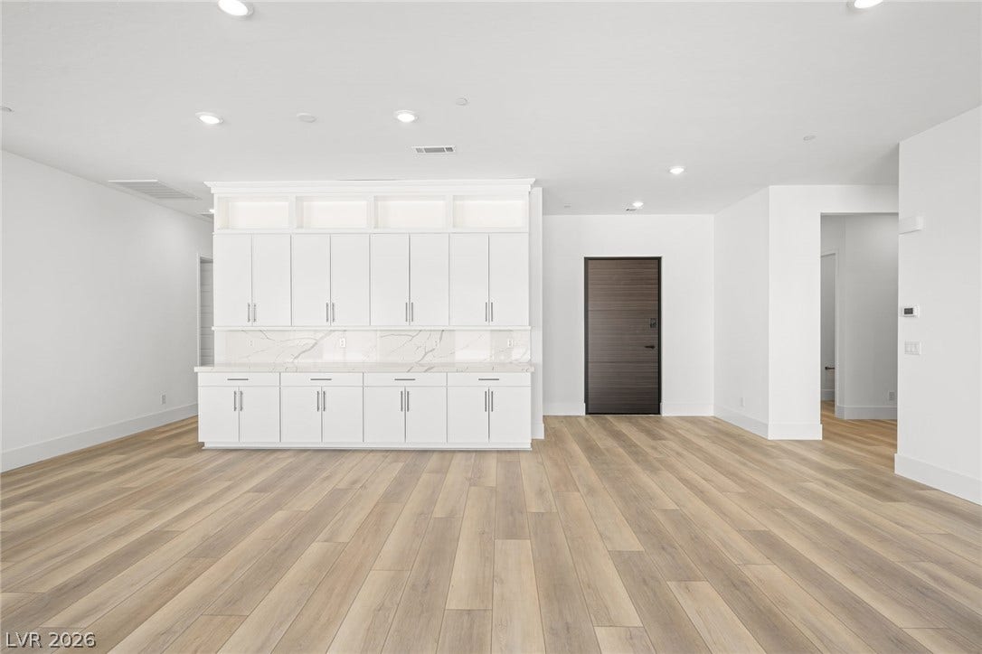 12428 Breezy Bluff Avenue, Las Vegas, NV 89138 Warm wood-look flooring anchors this open space accented by built-in cabinetry and recessed lighting.