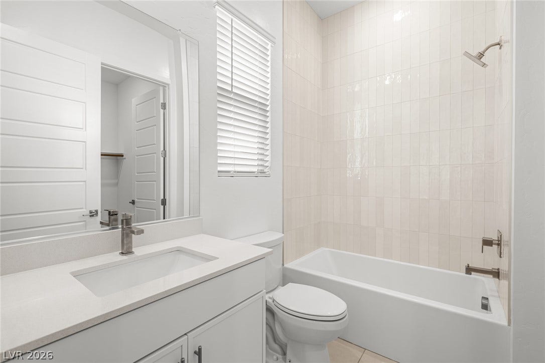 12428 Breezy Bluff Avenue, Las Vegas, NV 89138 Floor-to-ceiling vertical tile surrounds the built-in tub in this modern bathroom.
