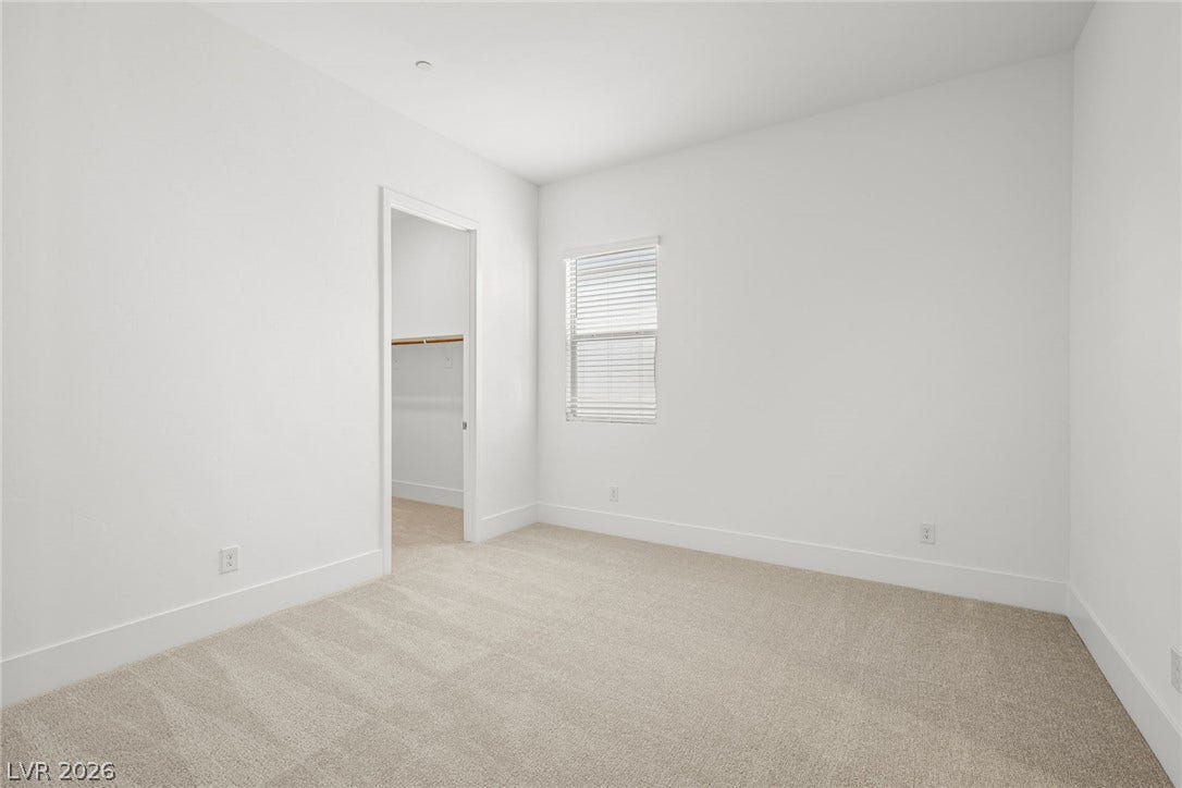 12428 Breezy Bluff Avenue, Las Vegas, NV 89138 Plush carpeting and crisp white walls define this comfortable bedroom space.