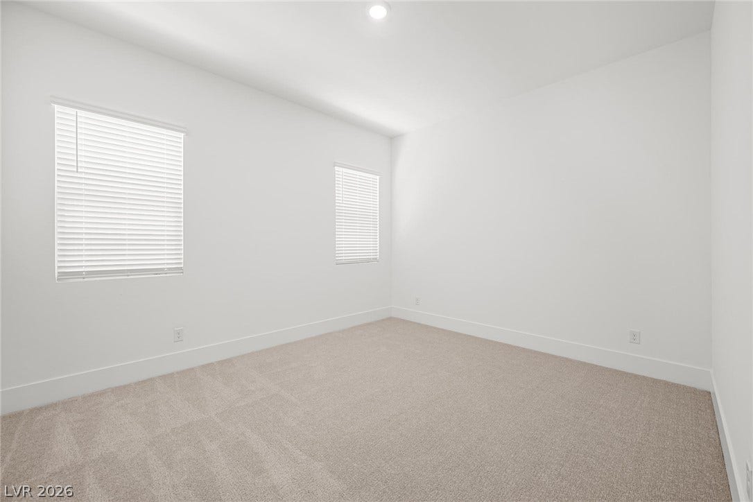 12428 Breezy Bluff Avenue, Las Vegas, NV 89138 Clean lines and soft carpeting define this minimalist bedroom space with recessed overhead lighting.