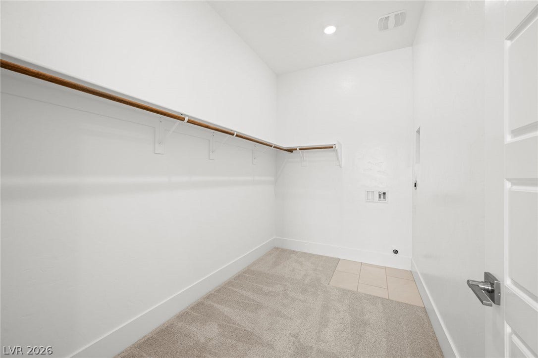 12428 Breezy Bluff Avenue, Las Vegas, NV 89138 A spacious walk-in closet includes carpet flooring, recessed lighting, and built-in wood hanging rods.
