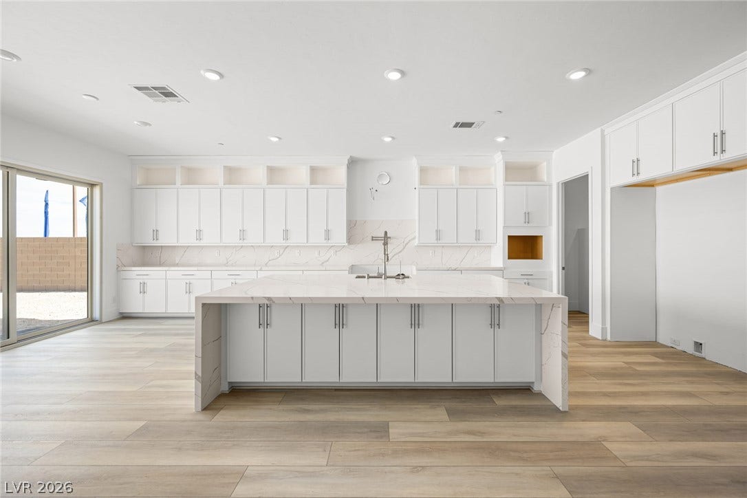 12428 Breezy Bluff Avenue, Las Vegas, NV 89138 An expansive central island anchors this modern kitchen finished with elegant stone countertops.