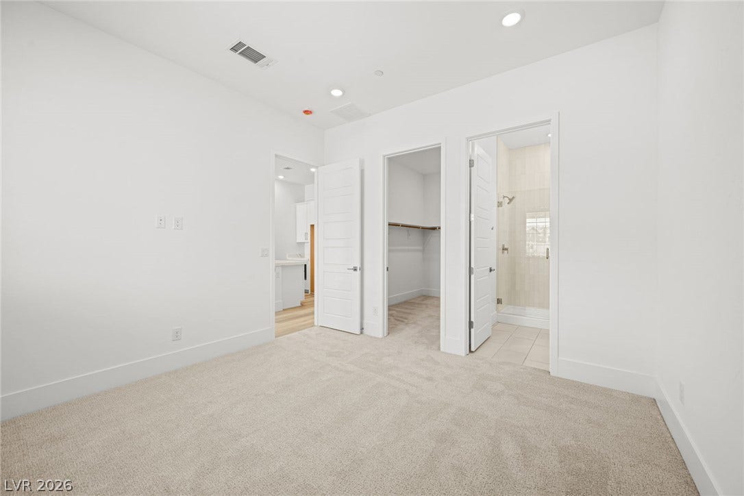 12428 Breezy Bluff Avenue, Las Vegas, NV 89138 Plush carpeting and recessed lighting define this bedroom with direct access to a private bathroom.
