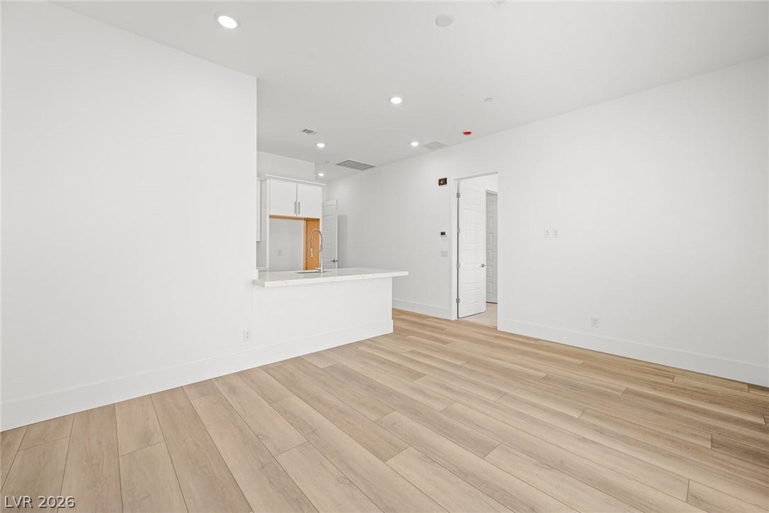12428 Breezy Bluff Avenue, Las Vegas, NV 89138 An open floor plan connects the living space to the kitchen over warm wood-style flooring.