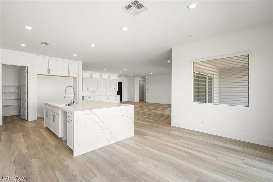 12428 Breezy Bluff Avenue, Las Vegas, NV 89138 An open floorplan seamlessly connects the stone-island kitchen with the main living areas.