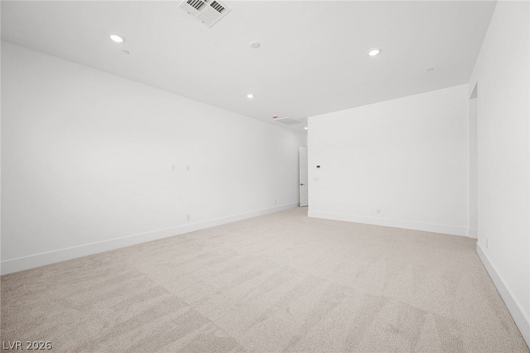 12428 Breezy Bluff Avenue, Las Vegas, NV 89138 Crisp white walls and plush carpeting define this versatile living space with recessed lighting.