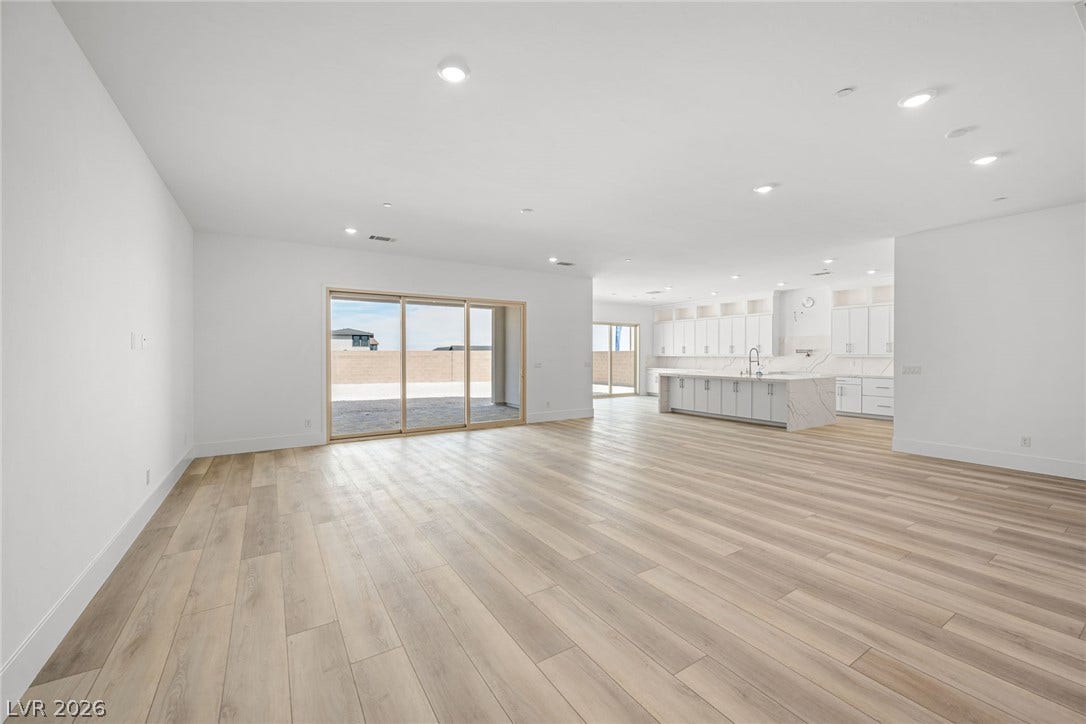 12428 Breezy Bluff Avenue, Las Vegas, NV 89138 Laminate wood flooring stretches across a spacious, open living area leading to the kitchen.