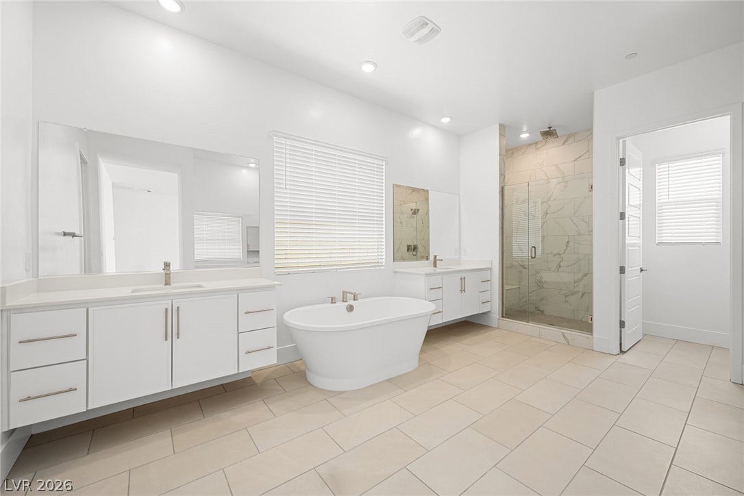 12428 Breezy Bluff Avenue, Las Vegas, NV 89138 An elegant freestanding soaking tub centers this master bath with double vanities and tiled floors.