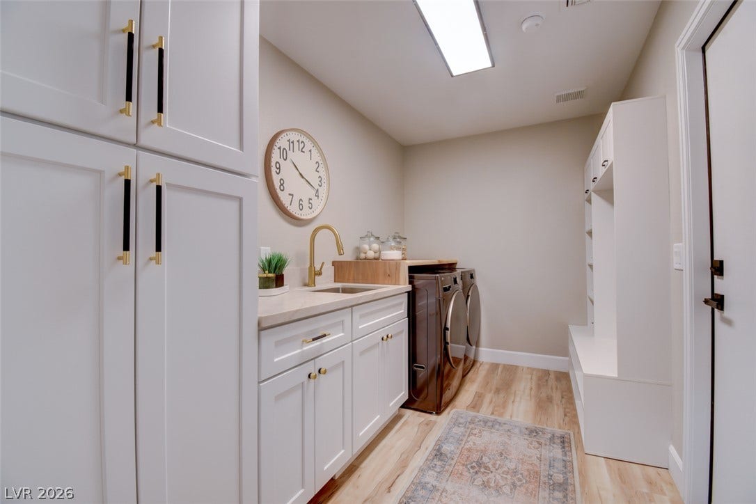 2837 Billy Casper Drive, Las Vegas, NV 89134 Huge laundry room, Hall Tree with coat rack & bench, lots of storage cabinets with hidden Built In Shark Robot vac. & mop, sink, front load washer & dryer. All brand new!