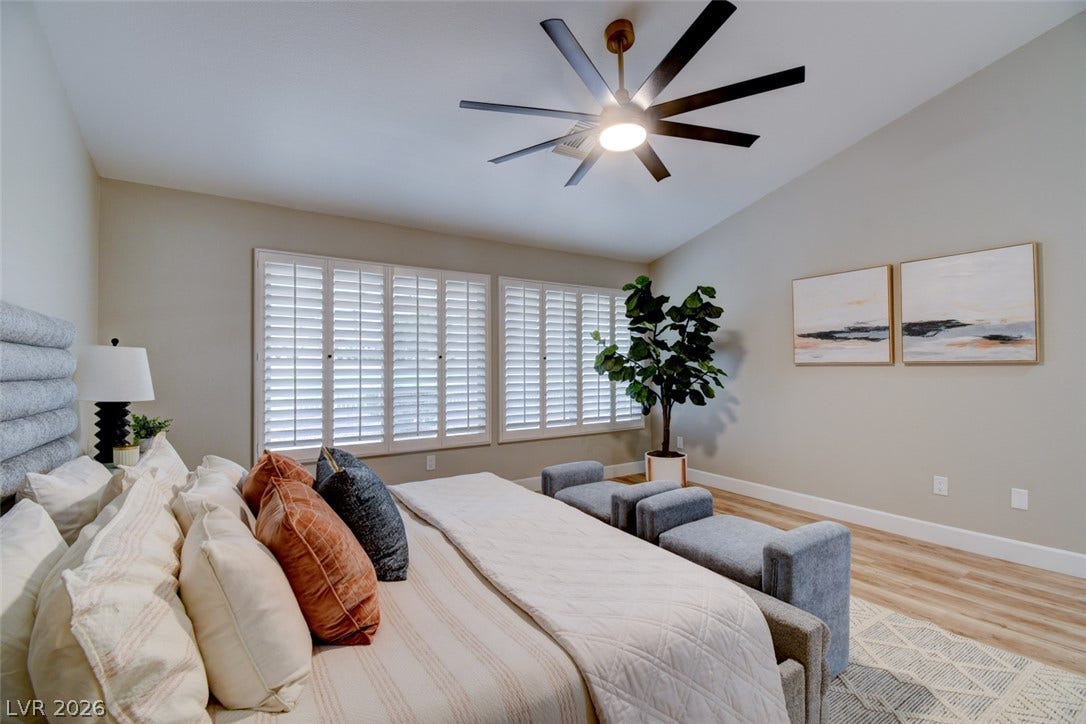 2837 Billy Casper Drive, Las Vegas, NV 89134 Vaulted ceilings and warm wood floors anchor this serene primary bedroom retreat. Wooden shutters with views of the golf course.