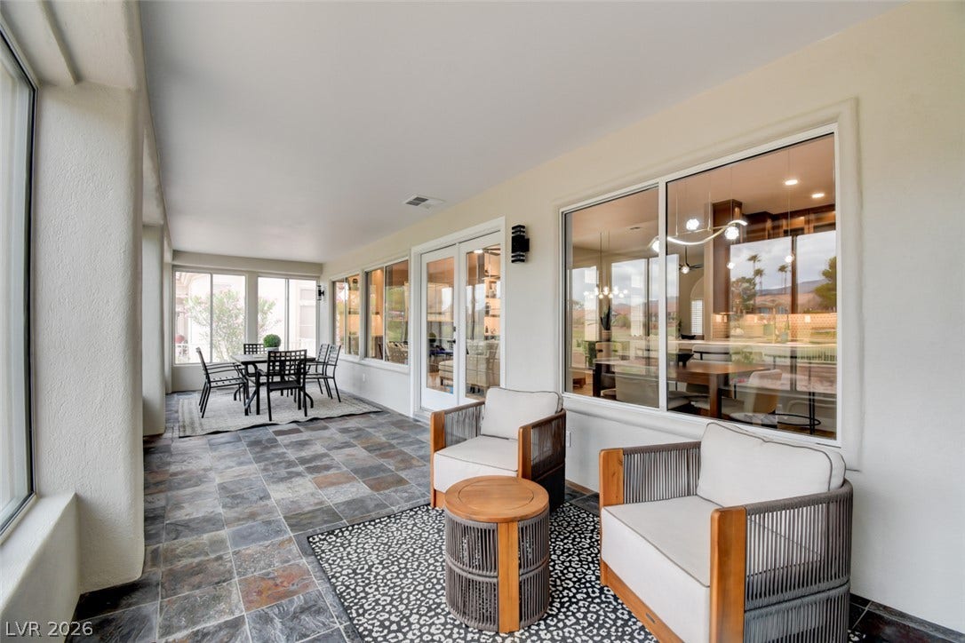 2837 Billy Casper Drive, Las Vegas, NV 89134 Natural stone tile flooring grounds a covered patio with direct access through glass French doors.