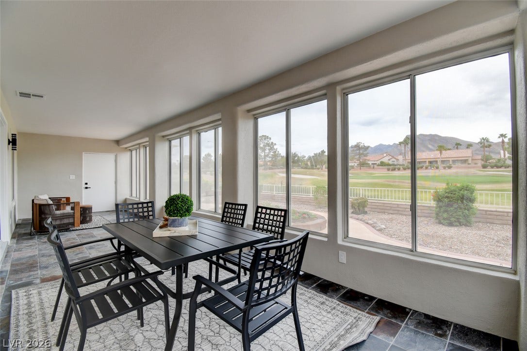 2837 Billy Casper Drive, Las Vegas, NV 89134 Wall-to-wall windows frame panoramic mountain and golf course views from this tiled sunroom.