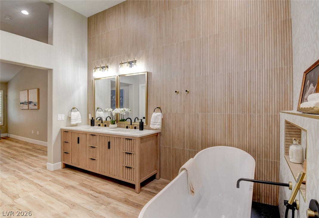 2837 Billy Casper Drive, Las Vegas, NV 89134 An elegant freestanding soaking tub anchors this beautifully appointed primary bathroom with dual vanities.