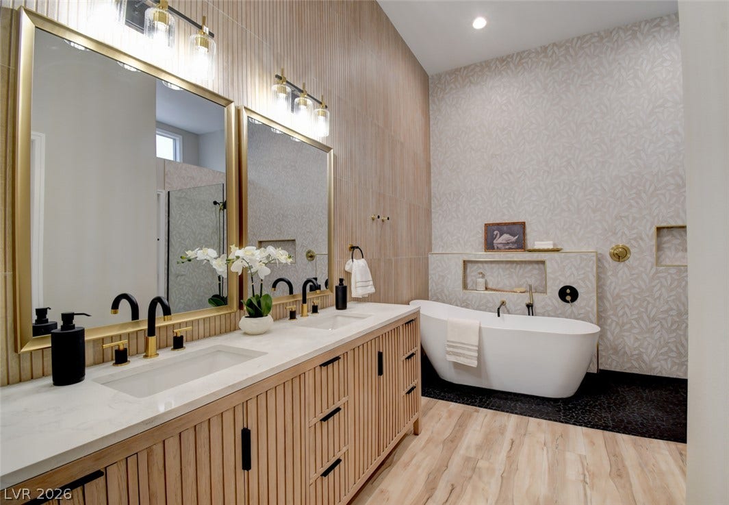 2837 Billy Casper Drive, Las Vegas, NV 89134 A freestanding tub and double vanity with modern wood detailing anchor this washroom.