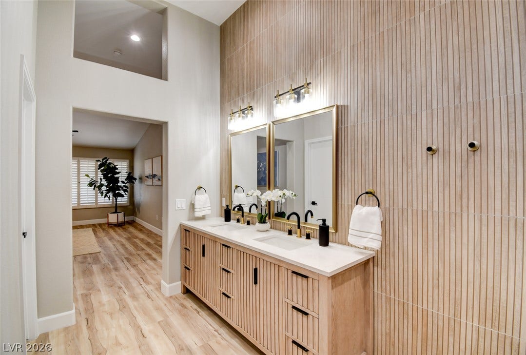 2837 Billy Casper Drive, Las Vegas, NV 89134 High ceilings and a textured accent wall elevate this modern double vanity with hair dryer & curling iron slits with power & USB inside.