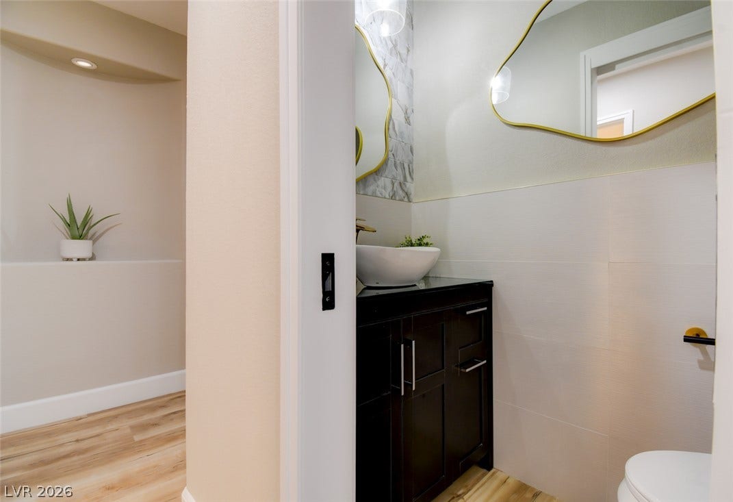 2837 Billy Casper Drive, Las Vegas, NV 89134 Elegant fixtures and tiled walls define this modern powder room.
