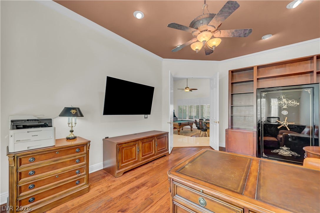 2030 Marina Bay Court, Las Vegas, NV 89117 Rich wood floors and custom built-in shelving anchor this versatile home workspace.