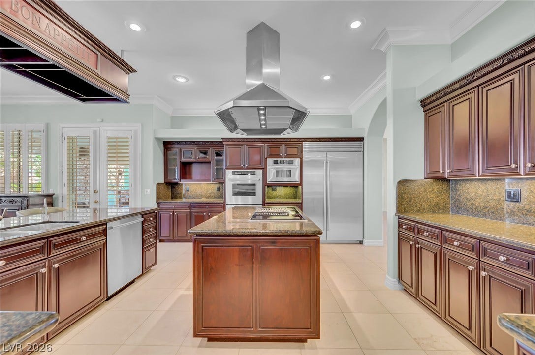 2030 Marina Bay Court, Las Vegas, NV 89117 Rich wood cabinetry paired with granite countertops anchors this spacious, light-filled kitchen design.