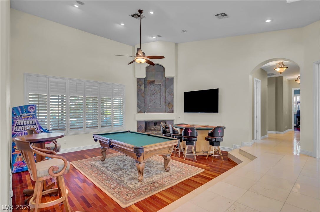 2030 Marina Bay Court, Las Vegas, NV 89117 Gleaming hardwood floors and a towering stone fireplace anchor this spacious recreation room.