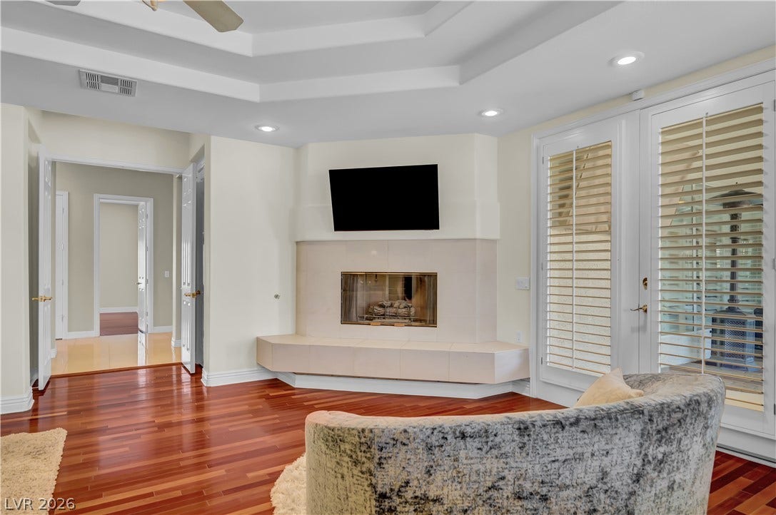 2030 Marina Bay Court, Las Vegas, NV 89117 Rich hardwood flooring complements a custom corner fireplace set beneath a classic tray ceiling.
