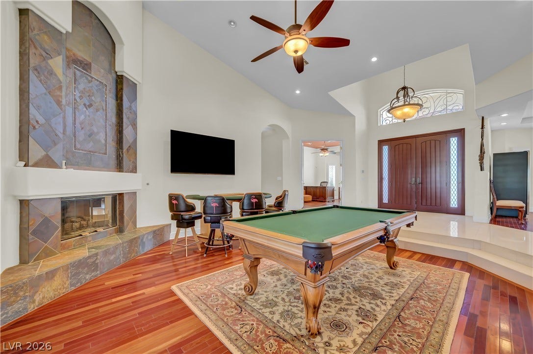 2030 Marina Bay Court, Las Vegas, NV 89117 Rich hardwood flooring complements a striking floor-to-ceiling tiled fireplace in this vaulted entryway room.