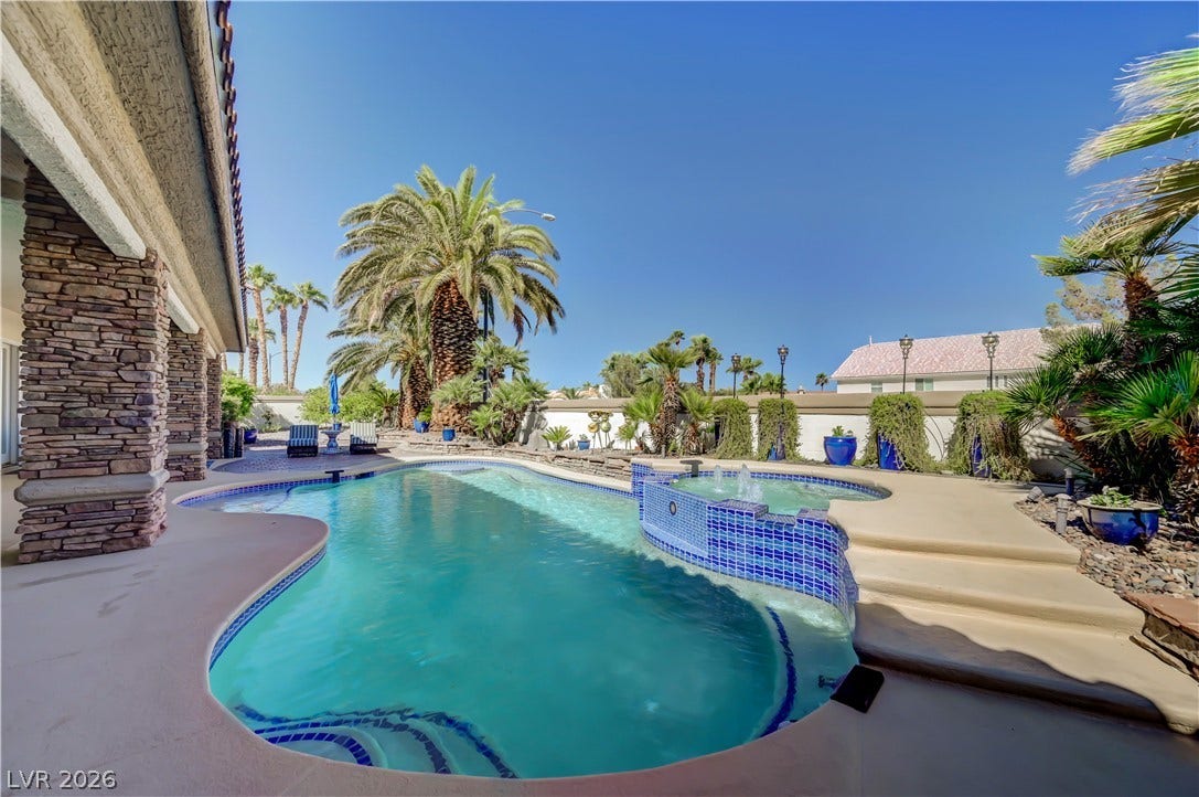 2030 Marina Bay Court, Las Vegas, NV 89117 An inviting backyard oasis showcases a sparkling pool alongside a raised spa and stone pillars.
