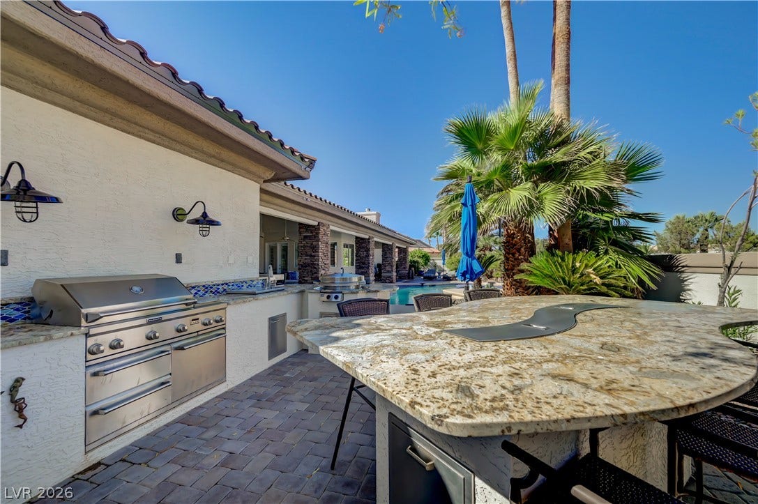 2030 Marina Bay Court, Las Vegas, NV 89117 An expansive granite island highlights this outdoor kitchen overlooking the backyard pool.