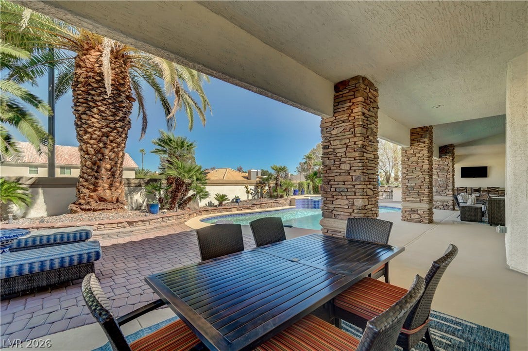 2030 Marina Bay Court, Las Vegas, NV 89117 Massive stone columns frame a shaded outdoor terrace overlooking the pool and tropical palms.