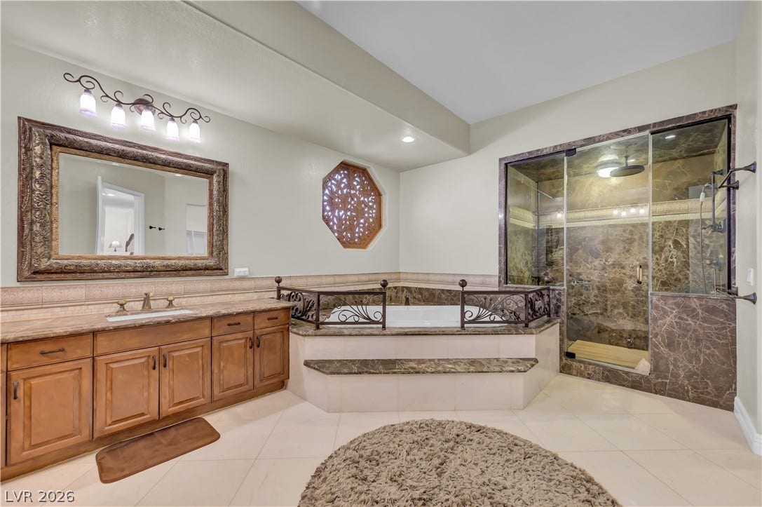 2030 Marina Bay Court, Las Vegas, NV 89117 Rich stone finishes elevate this main bath with an integrated tub and glass shower.