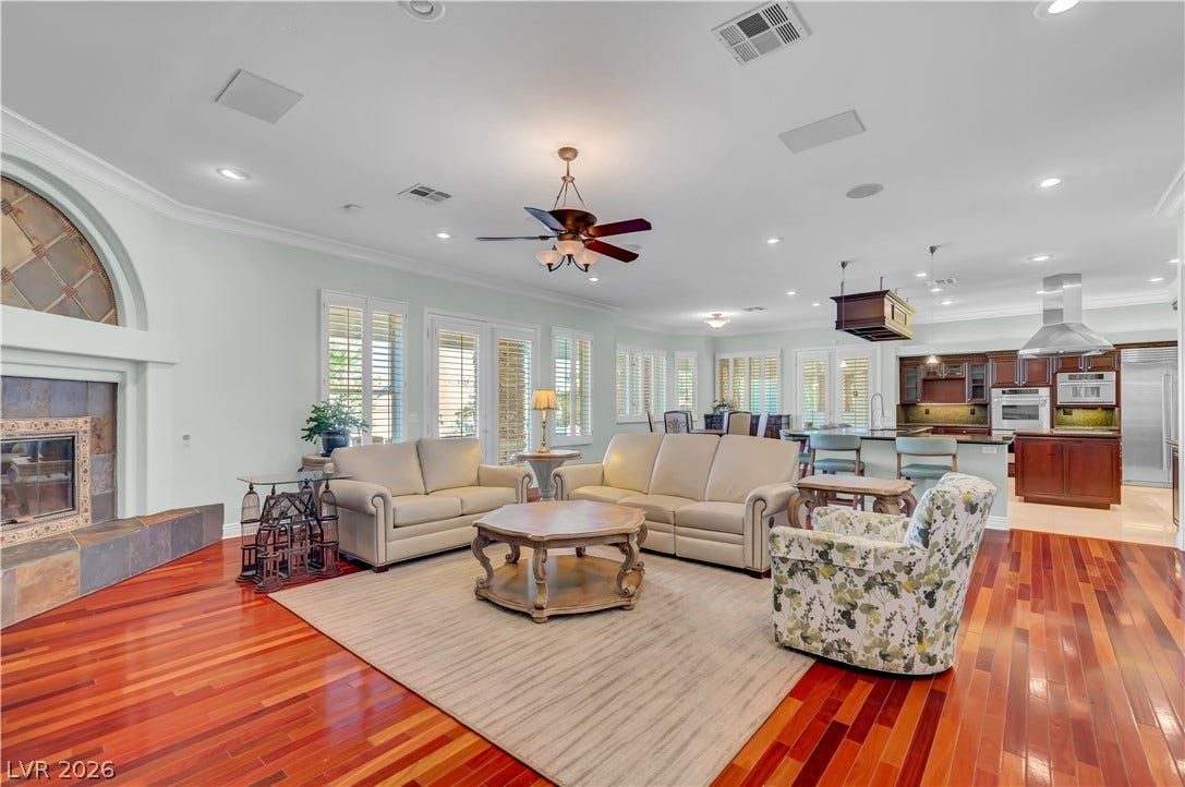2030 Marina Bay Court, Las Vegas, NV 89117 Rich hardwood flooring sweeps across a spacious open living area framed by elegant window shutters.