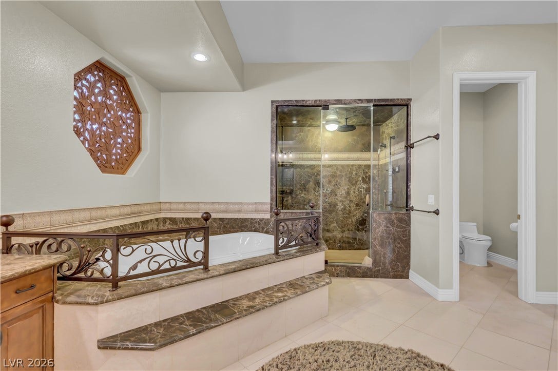 2030 Marina Bay Court, Las Vegas, NV 89117 An elegant soaking tub and walk-in shower highlight this luxurious primary bathroom space.