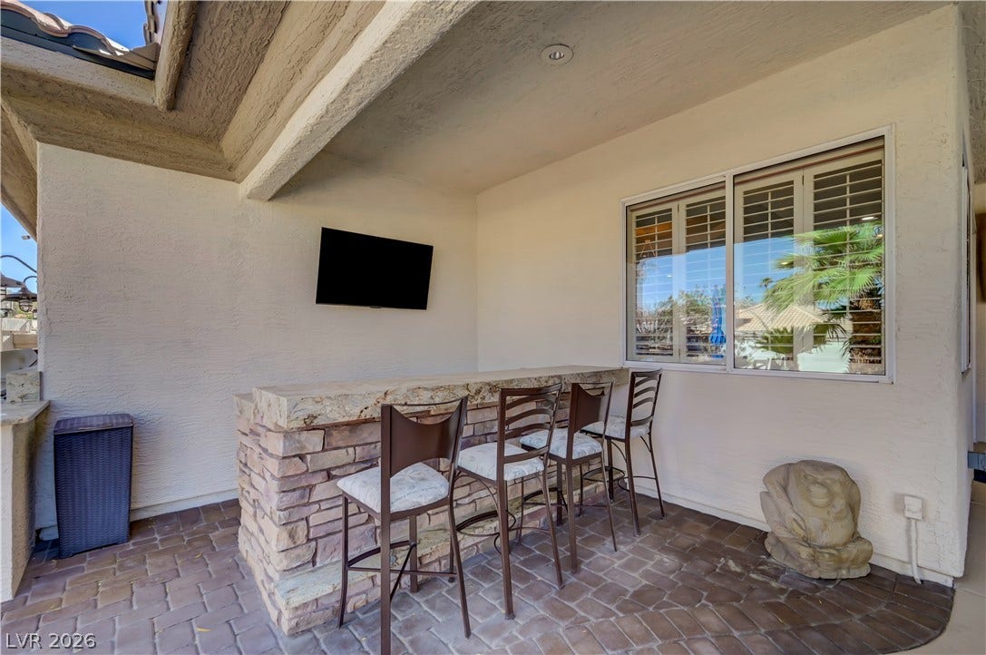 2030 Marina Bay Court, Las Vegas, NV 89117 A covered patio features a stone-accented bar counter set against a brick paver floor.