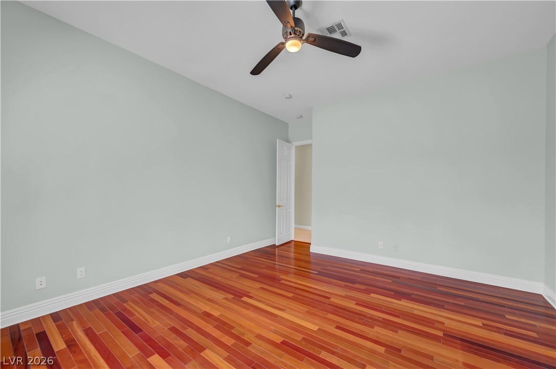 2030 Marina Bay Court, Las Vegas, NV 89117 Richly toned hardwood floors ground this versatile secondary bedroom with crisp white trimwork.