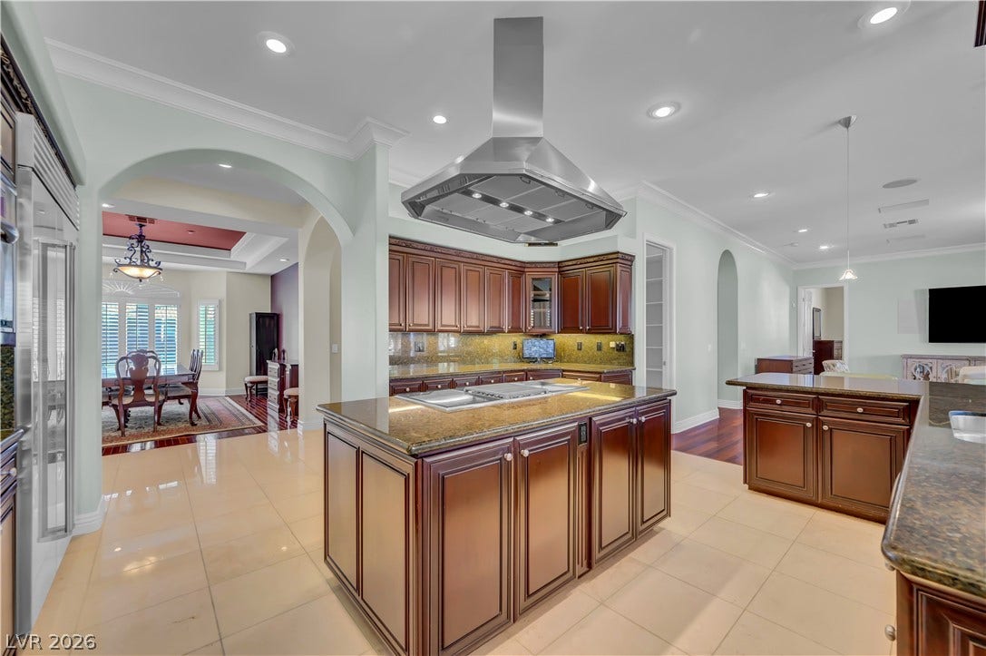 2030 Marina Bay Court, Las Vegas, NV 89117 Rich wood cabinetry and polished stone countertops anchor this spacious, well-lit kitchen area.