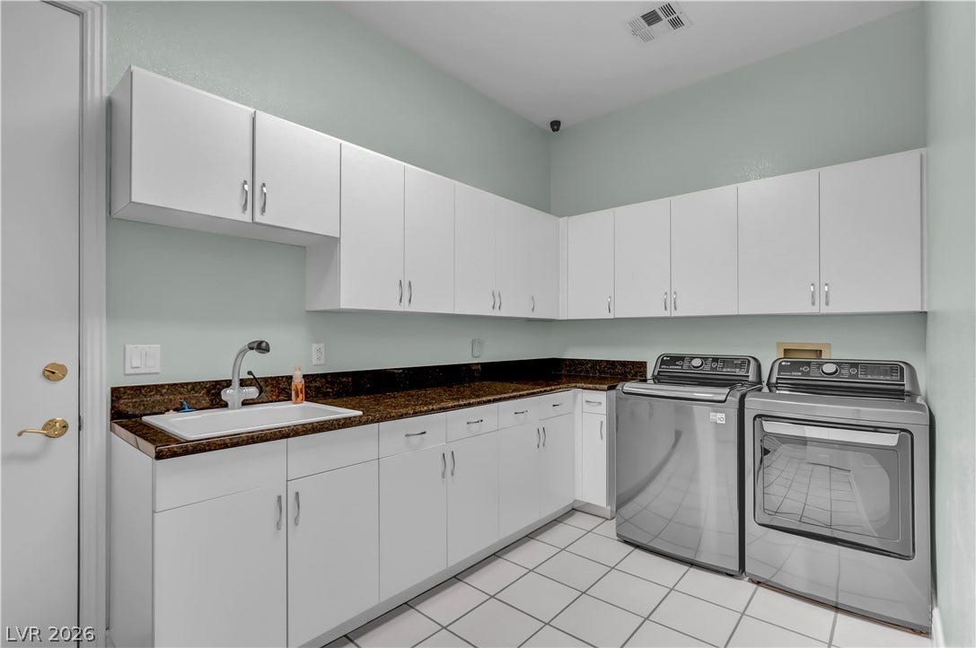 2030 Marina Bay Court, Las Vegas, NV 89117 Ample cabinetry and stone countertops elevate this functional laundry space with tiled flooring.