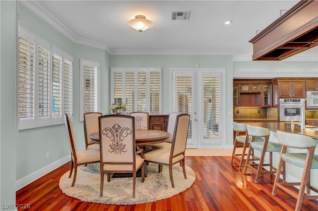 2030 Marina Bay Court, Las Vegas, NV 89117 Rich hardwood floors and elegant crown molding elevate this open dining and kitchen area.