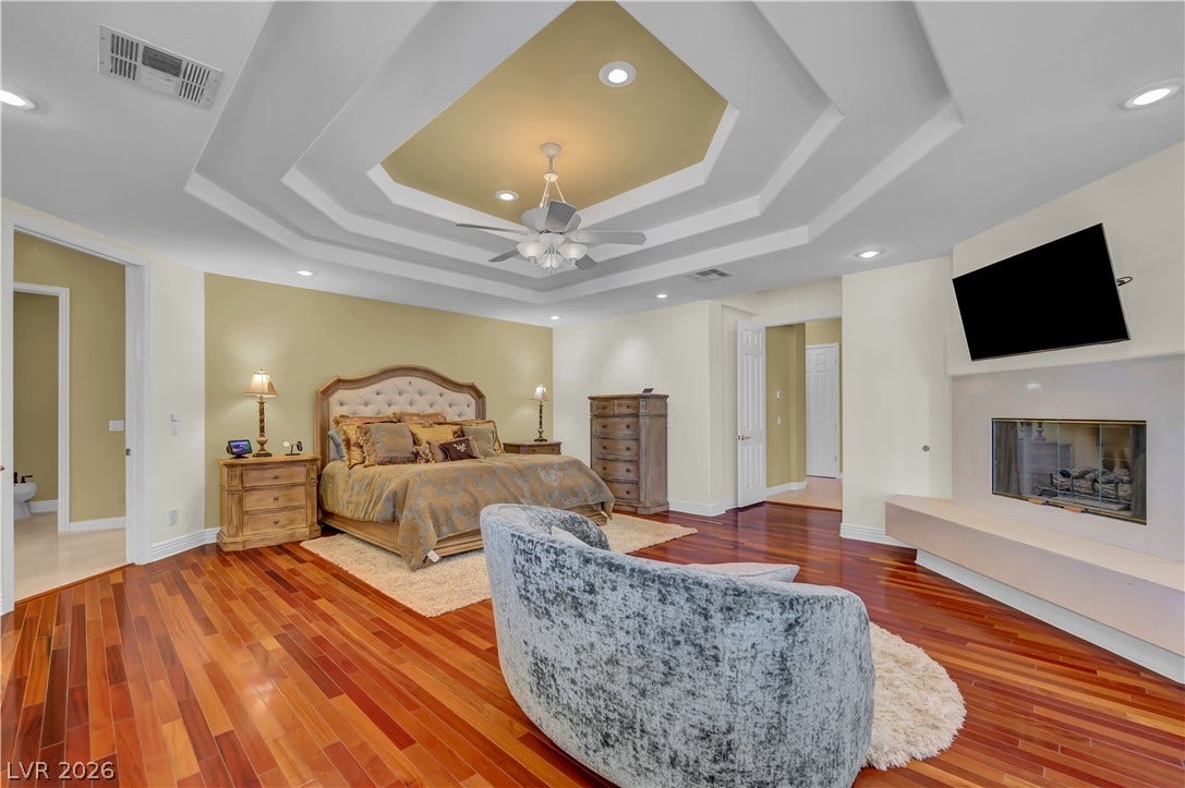 2030 Marina Bay Court, Las Vegas, NV 89117 Gleaming hardwood floors and a tiered tray ceiling anchor this comfortable primary bedroom suite.