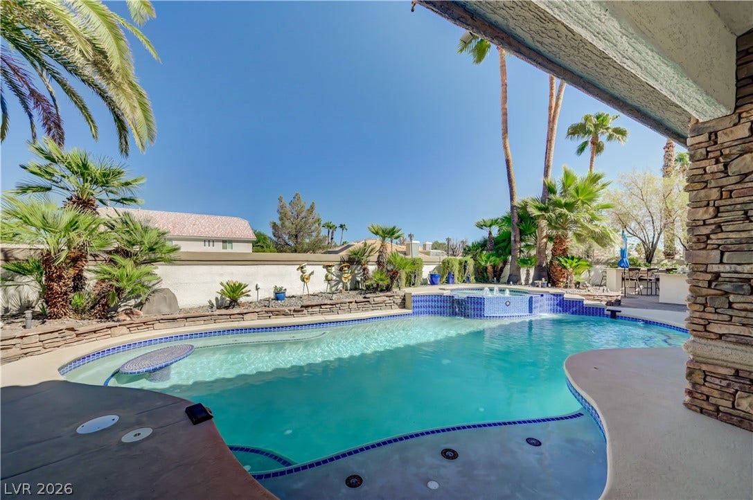 2030 Marina Bay Court, Las Vegas, NV 89117 An inviting backyard oasis features a sparkling swimming pool, integrated spa, and tropical palm trees.