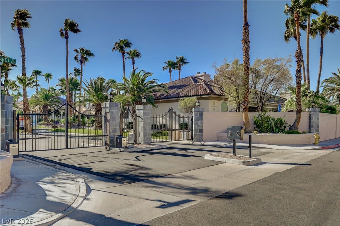 2030 Marina Bay Court, Las Vegas, NV 89117 Secure gated entryway leads to a beautifully landscaped property surrounded by mature palm trees.