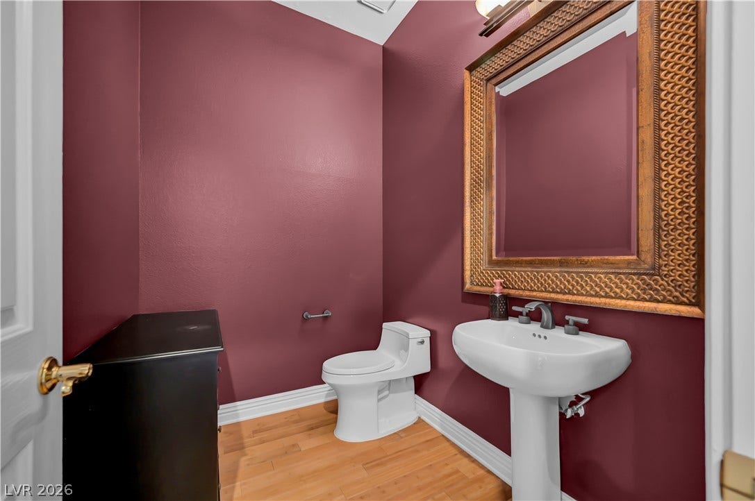 2030 Marina Bay Court, Las Vegas, NV 89117 Richly toned walls and warm wood flooring define this elegant powder room.