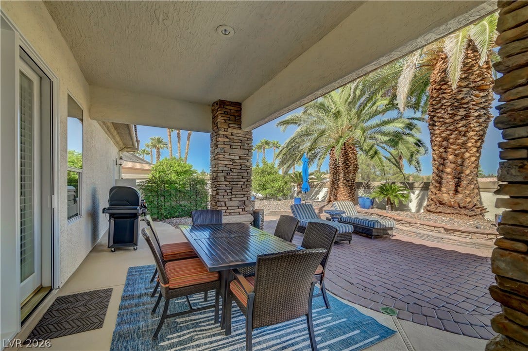 2030 Marina Bay Court, Las Vegas, NV 89117 Shaded outdoor dining space looks out over a paved patio area framed by palm trees.