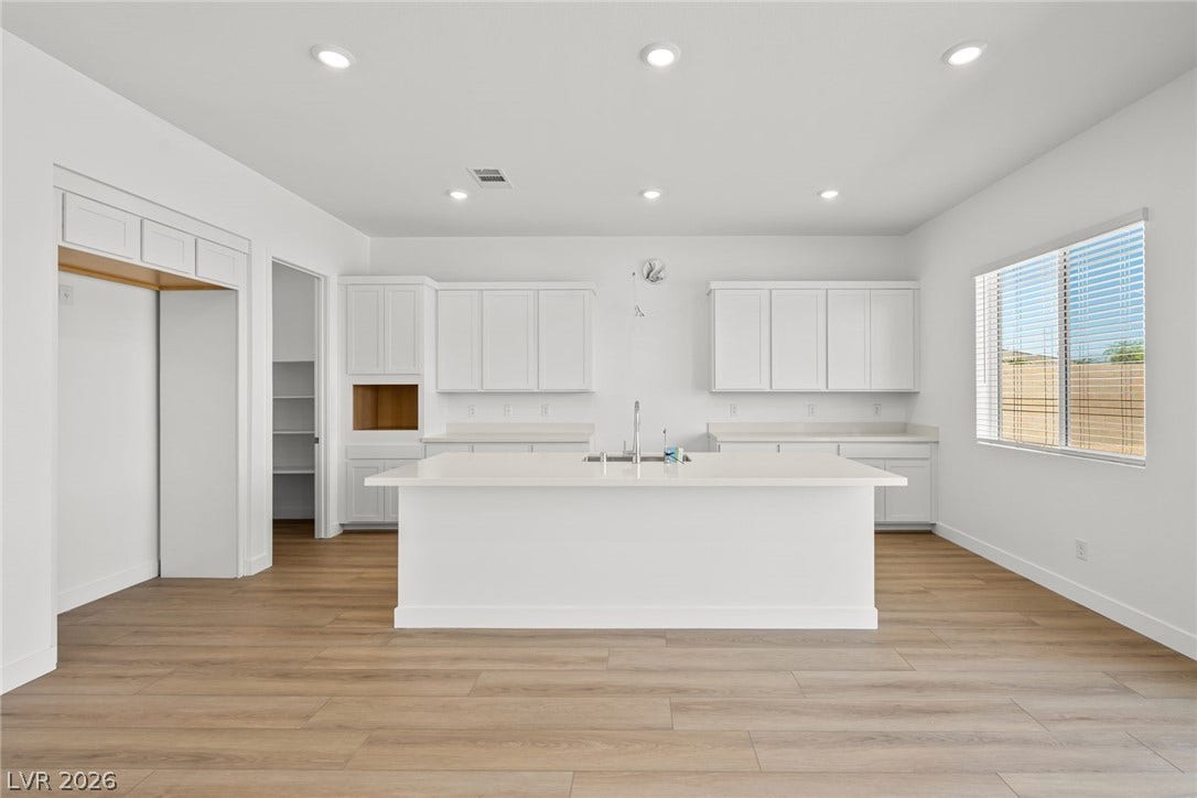 Gleaming stone countertops and a spacious central island anchor this open kitchen design.