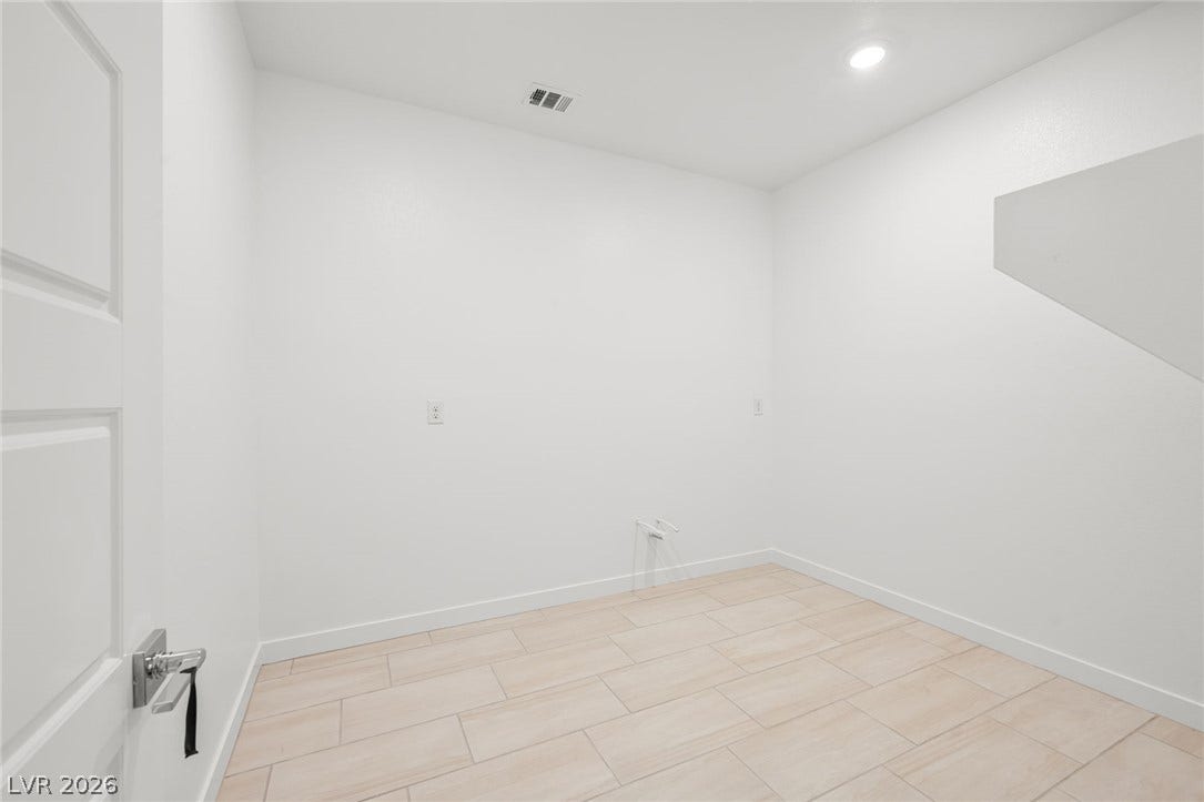 Tiled flooring and clean white walls define this versatile utility space.