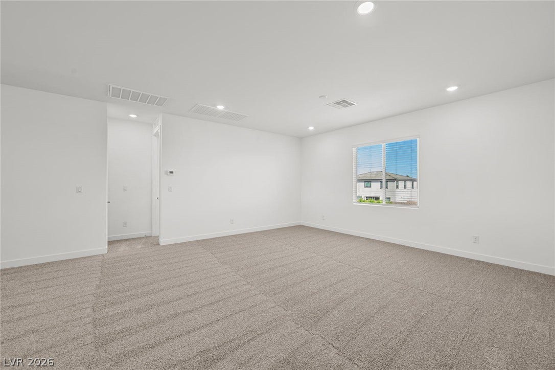 Plush carpeting and recessed lighting define this versatile upstairs loft space.