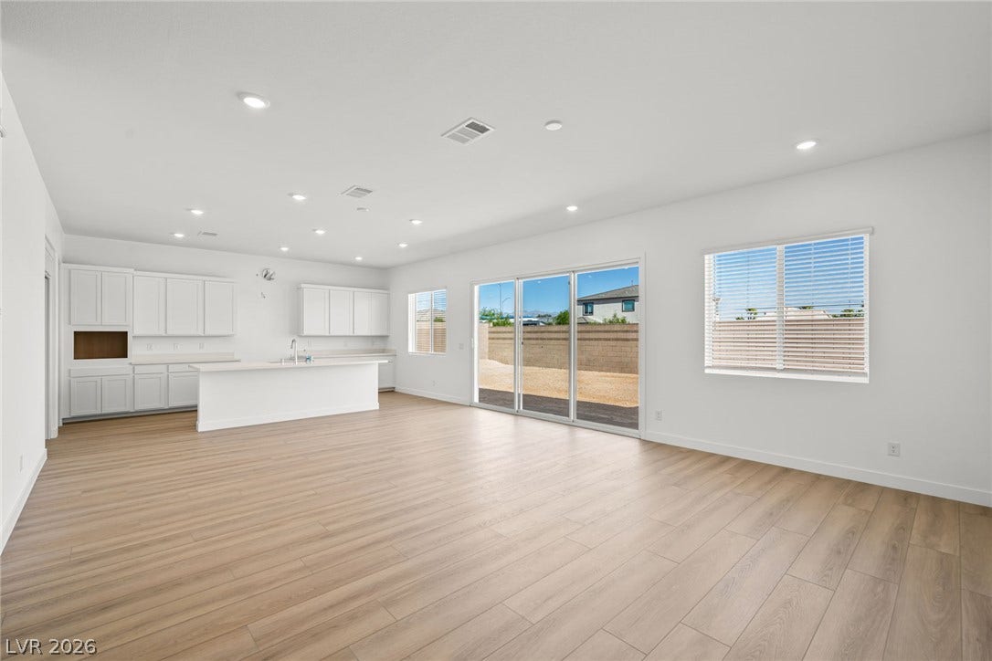 Warm wood flooring and clean lines define this expansive, light-filled open concept living area.