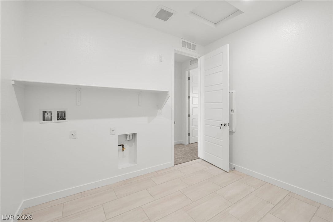 Tiled flooring and a long storage shelf define this dedicated utility space.