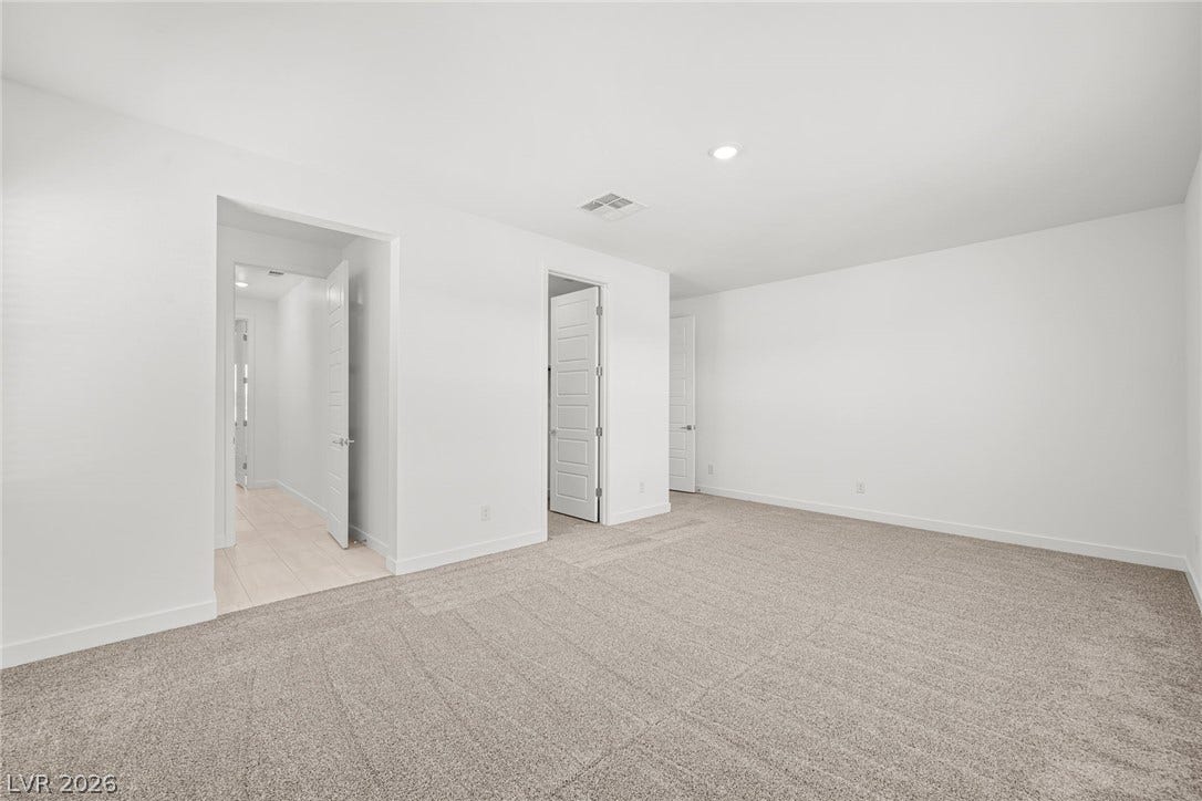Plush neutral carpeting underfoot defines this versatile secondary bedroom or home office space.